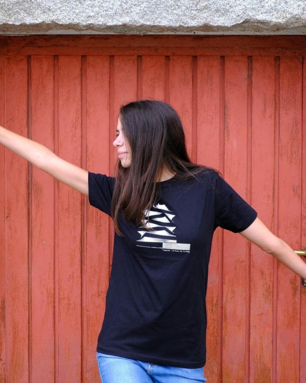 Chica con camiseta negra estampada con el edificio La Pagoda, frente a una puerta roja