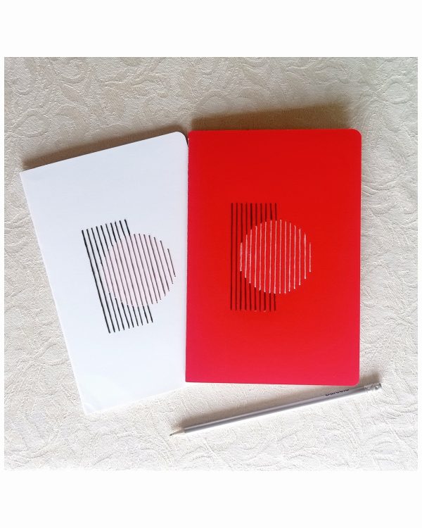 Dos libretas A5 bordadas a mano con un círculo, una blanca y una roja