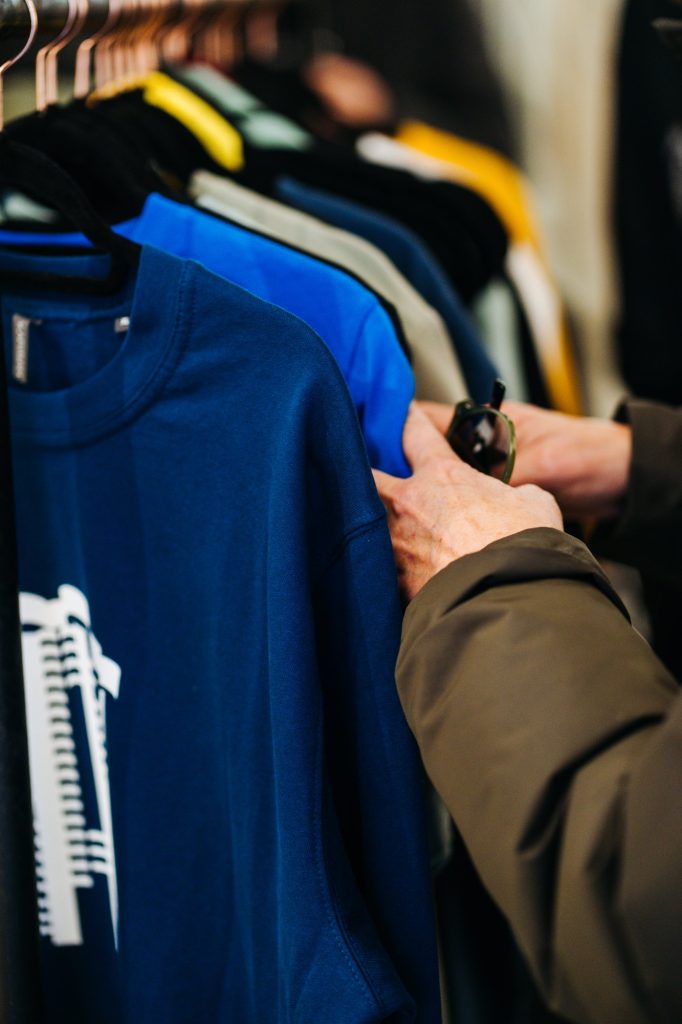 Sudadera Torres Blancas en azul tinta colgada en un perchero